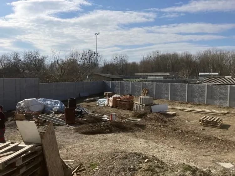 Szürke kőmintás betonkerítés egy építési telken