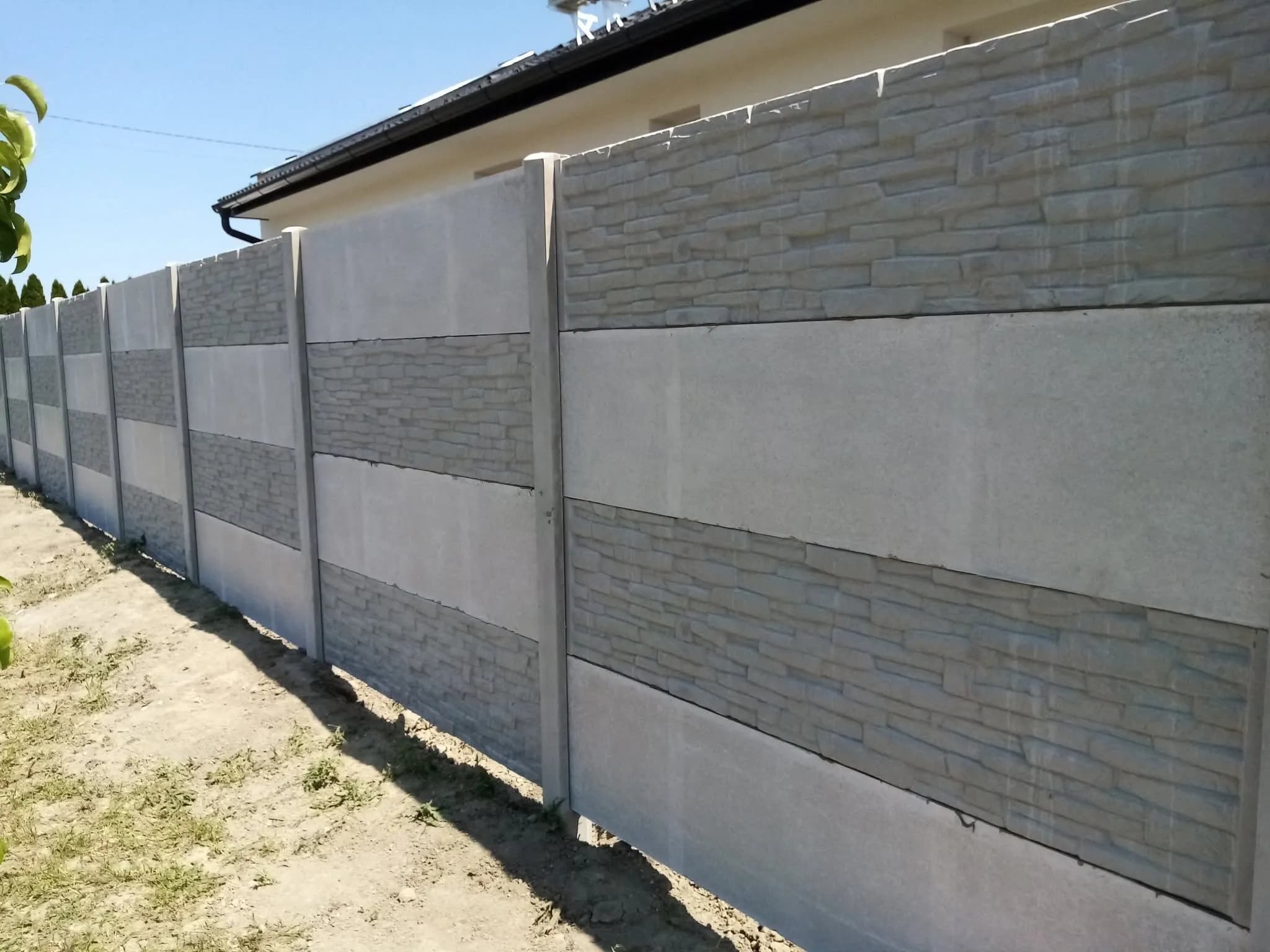 Kerítés váltakozó sima és kőmintás sorokkal